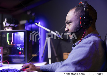 Man angry after losing while playing videogames in neon lit apartment. Irked gamer frustrated with defeat during multiplayer game, shot by other players, showing negative emotion 113009893
