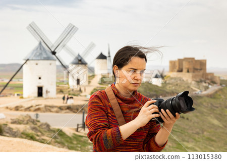 Woman tourist with a camera Consuegra photographs the surroundings Woman tourist with a camera Consuegra photographs the surroundings 113015380
