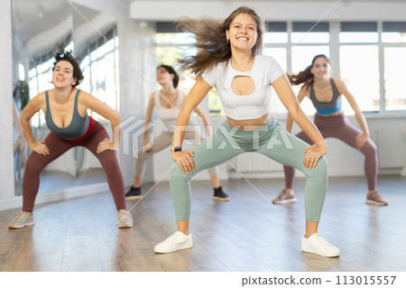 Enthusiastic young girl honing hip-hop moves in dance studio 113015557