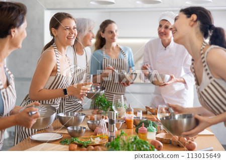 Young woman talks and drinks with group during master class 113015649