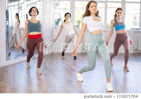 Young female teacher conducts modern dance lessons for group of girls Young female teacher conducts modern dance lessons for group of girls 113015784