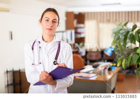 Woman doctor wear white medical uniform with folder of documents Woman doctor wear white medical uniform with folder of documents 113015883