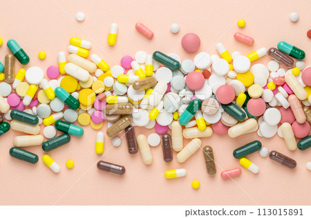 Many different pills on pink background. Prescription pills and vitamins. Flat lay and space for text. 113015891