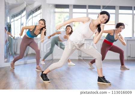 Young female teacher conducts modern dance lessons for group of girls Young female teacher conducts modern dance lessons for group of girls 113016009