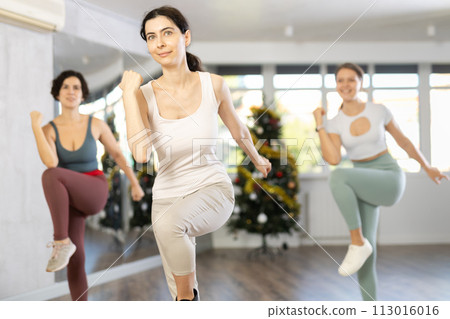 Slender young women dancers dance a twist in a modern way during Christmas celebration 113016016