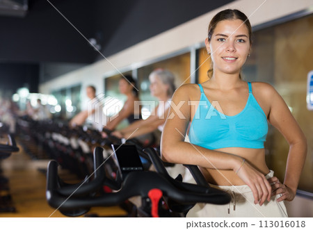 Young girl on training using bike in gym Young girl on training using bike in gym 113016018