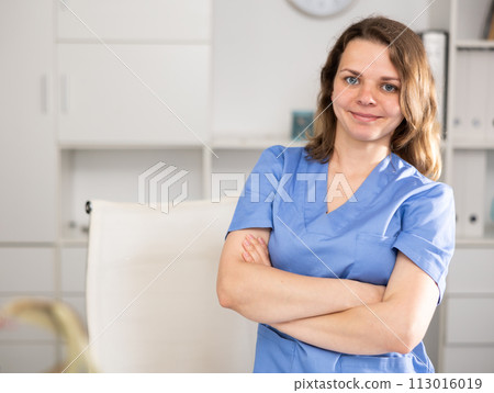 Portrait of female doctor who is working and posing on her workplace in clinic. Portrait of female doctor who is working and posing on her workplace in clinic. 113016019