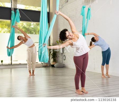 Sporty women are warming up before doing aerial yoga 113016138