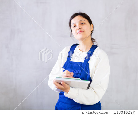 Positive female cleaning service worker noting details of order 113016287