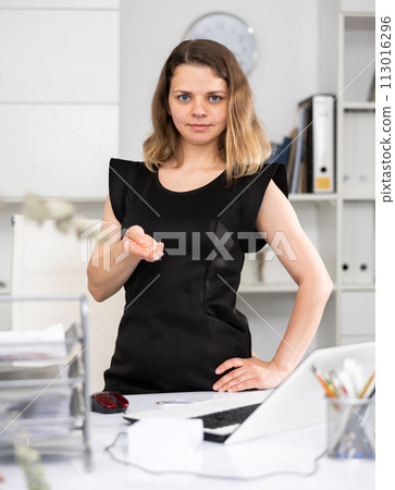 Portrait of female manager making palm gesture 113016296