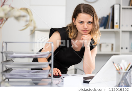 Portrait of businesswoman leaning on table in office 113016302