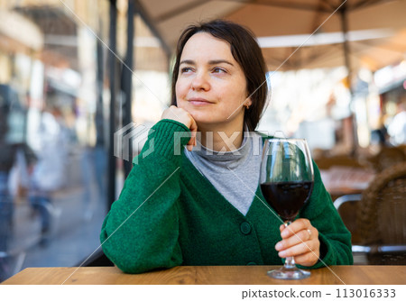 Young adult woman drinking wine at restaurant Young adult woman drinking wine at restaurant 113016333