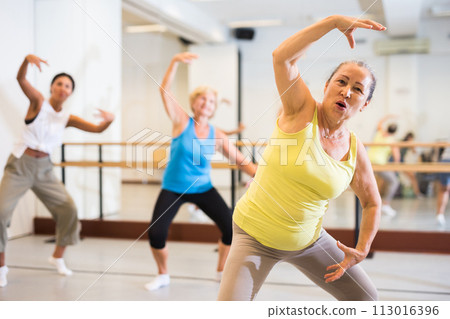 Old lady dancing in studio with women 113016396