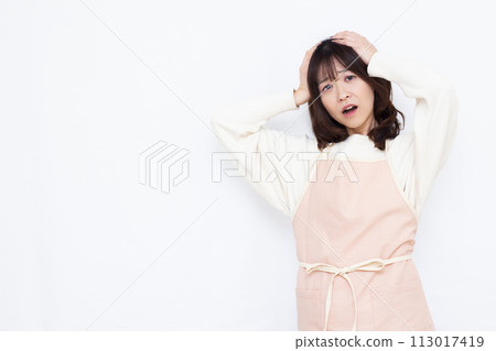 Housewife holding her head in surprise 113017419
