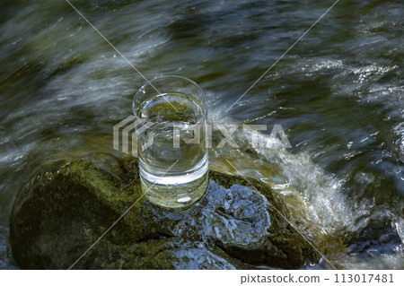 Natural water poured into a glass 113017481