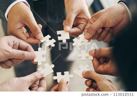 The concept of teamwork and partnership. Businessman's hands putting together puzzle pieces in the office and join together in a jigsaw puzzle team. Charity. Volunteers. Business unity as a team. 113018531