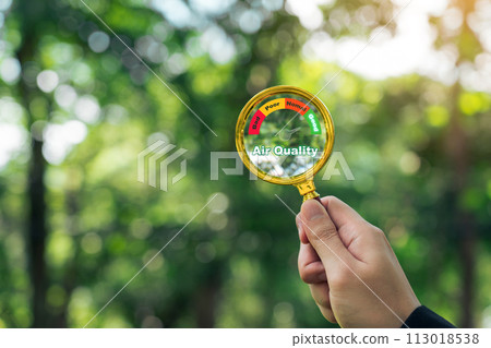 Hand holding a magnifying glass to check the good air quality and clean outdoor air quality safe. 113018538