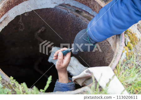 Sewer works. Industrial sewage treatment. Give a screwdriver for the worker in the sewer manhole. 113020611