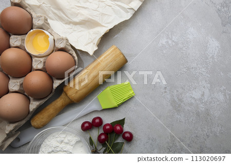 Ingredients baking flour eggs rolling pin berries kitchen textiles on gray background. Cookie pie or cake recipe mockup. Preparing for culinary baking. Ingredients baking flour eggs rolling pin berries kitchen textiles on gray background. Cookie pie or cake recipe mockup. Preparing for culinary baking. 113020697