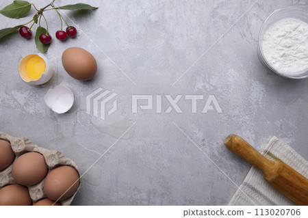Ingredients baking flour eggs rolling pin berries kitchen textiles on gray background. Cookie pie or cake recipe mockup. Preparing for culinary baking. 113020706