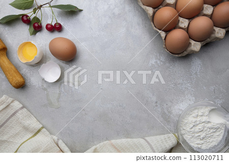 Ingredients baking flour eggs rolling pin berries kitchen textiles on gray background. Cookie pie or cake recipe mockup. Background preparation for culinary baking. Ingredients baking flour eggs rolling pin berries kitchen textiles on gray background. Cookie pie or cake recipe mockup. Background preparation for culinary baking. 113020711