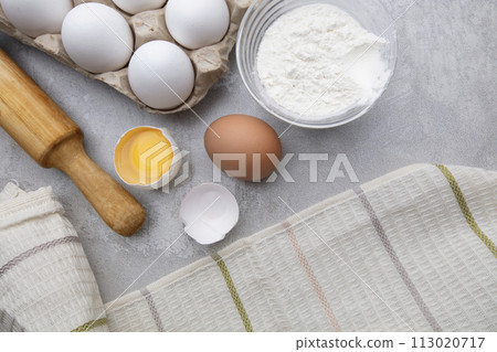 Baking cooking ingredients flour eggs rolling pin and kitchen textiles on gray concrete background. Cookie pie or cake recipe mockup Baking cooking ingredients flour eggs rolling pin and kitchen textiles on gray concrete background. Cookie pie or cake recipe mockup 113020717