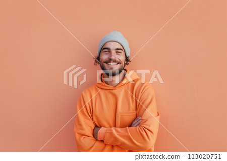 AI-generated content. Waist up portrait of funky young man smiling at camera and wearing bright orange hoodie on pech background generated AI image copy space 113020751