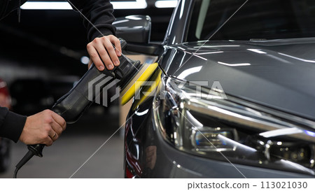 A master polishes the surface of a car body.  113021030