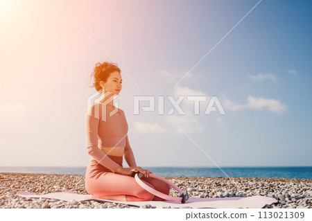 Woman sea pilates. Sporty happy middle aged woman practicing fitness on beach near sea, smiling active female training with ring on yoga mat outside, enjoying healthy lifestyle, harmony and meditation 113021309