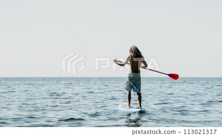 Man Sup Sea. Strong athletic man learns to paddle sup standing on board in open sea ocean on sunny day. Summer holiday vacation and travel concept. Aerial view. Slow motion Man Sup Sea. Strong athletic man learns to paddle sup standing on board in open sea ocean on sunny day. Summer holiday vacation and travel concept. Aerial view. Slow motion 113021317