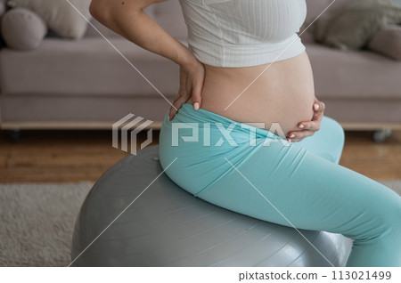 Caucasian pregnant woman suffers from belly pain. Fitball training during pregnancy. Caucasian pregnant woman suffers from belly pain. Fitball training during pregnancy. 113021499