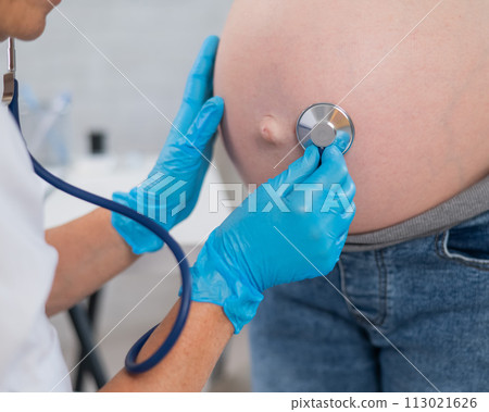 The doctor listens to the heartbeat of the baby of a pregnant woman. The doctor listens to the heartbeat of the baby of a pregnant woman. 113021626