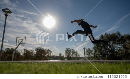 Caucasian man jumping with high hip raise outdoors.  113021933