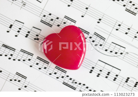 Red heart on paper with musical notes close-up. 113023273