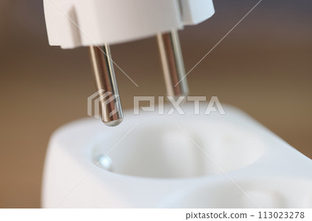 Close-up of inserting electric plug into socket. 113023278