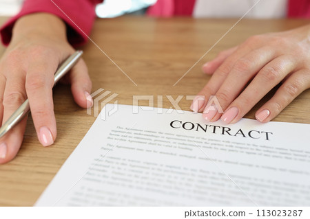 Female manager asks client to sign contract in her office. 113023287
