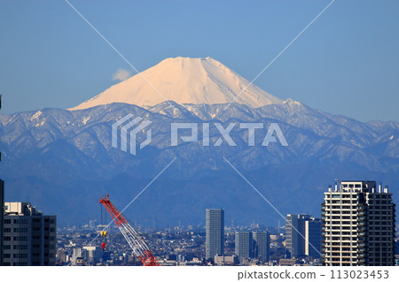 A snow covered Mt. Fuji as seen from Shibaura Island of Minatoku in central Tokyo Japan, with a border of modern construction of tall buildings A snow covered Mt. Fuji as seen from Shibaura Island of Minatoku in central Tokyo Japan, with a border of modern construction of tall buildings 113023453