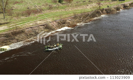 Men Dressed As US American Soldiers Of USA Infantry Of World War II carry out rafting on rubber boats In spring Autumn Day. Group of Soldiers people are preparing to disembark. Aerial view elevated 113023909