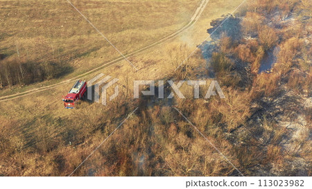Aerial View. Spring Dry Grass Burns During Drought Hot Weather. Bush Fire And Smoke. Fire Engine, Fire Truck On Firefighting Operation. Wild Open Fire Destroys Grass. Ecological Problem Air Pollution 113023982