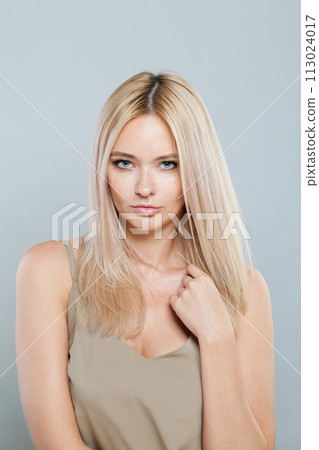 Posing blonde person portrait. Beauty woman with clear shiny fresh skin and blond hair 113024017