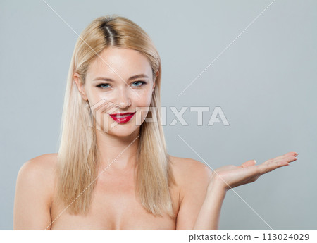 Female face and empty palm hand. Young blonde woman on white background Female face and empty palm hand. Young blonde woman on white background 113024029