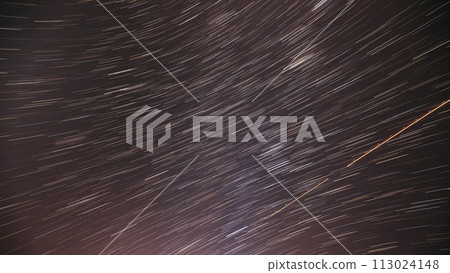 Spin Of Unusual Amazing Stars Effect In Sky. . Bewitching Illusion Of Star Trails. Meteors Trace On Night Dark Blue Sky Background. , . Rotate Of Sky Background 113024148