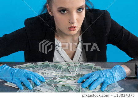 Scattered paper banknotes on the counter of a young cashier during a lot of money. Scattered paper banknotes on the counter of a young cashier during a lot of money. 113024375