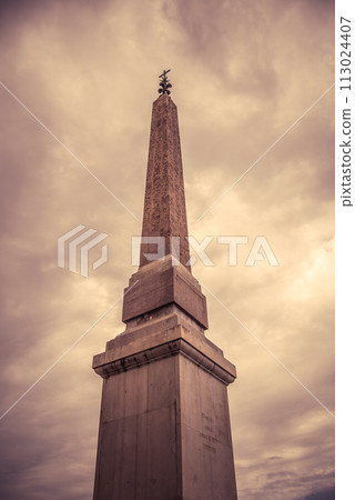 The ancient Sallustiano Obelisk rises majestically, its hieroglyphics visible against a dramatic, cloud-filled sky, evoking Romes historical grandeur. Rome, Italy The ancient Sallustiano Obelisk rises majestically, its hieroglyphics visible against a dramatic, cloud-filled sky, evoking Romes historical grandeur. Rome, Italy 113024407