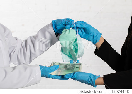 The doctor gives masks and the other woman hands her a large bundle of paperwork. 113024458