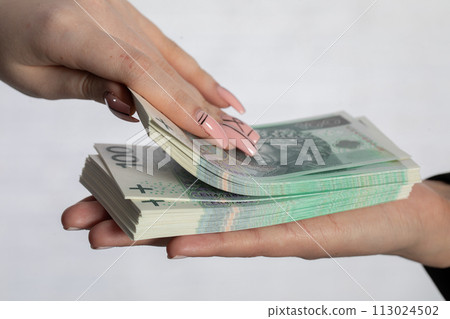 During the transaction, a woman's hand looks through a bundle of paper banknotes. During the transaction, a woman's hand looks through a bundle of paper banknotes. 113024502