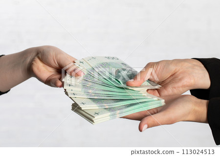 A woman's hand draws a banknote that may bring her luck in the future. A woman's hand draws a banknote that may bring her luck in the future. 113024513