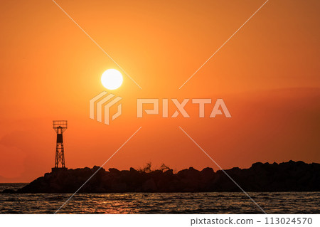 A beautiful sunrise sky behind a lighthouse.Skala Potamias, Thassos, Greece A beautiful sunrise sky behind a lighthouse.Skala Potamias, Thassos, Greece 113024570