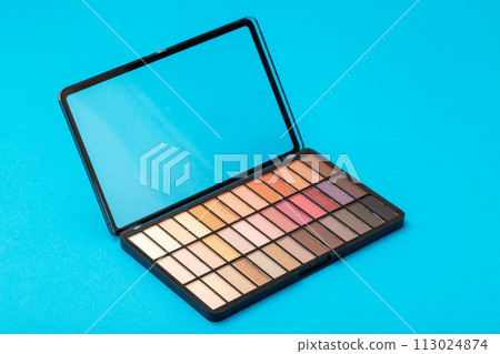 A set of modern eye shadows with powdery shades on a blue background. Soft texture and shading, brand, close-up. 113024874