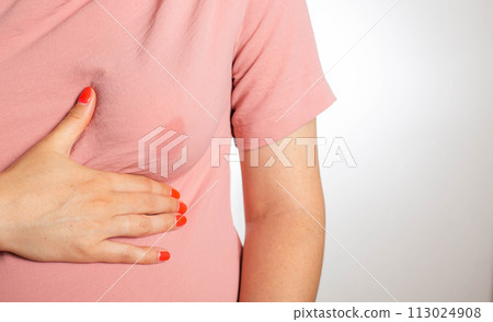 A soaked blouse from milk on the female breast of a nursing mother. Leak-proof bra pads, close-up. Copy space for text 113024908